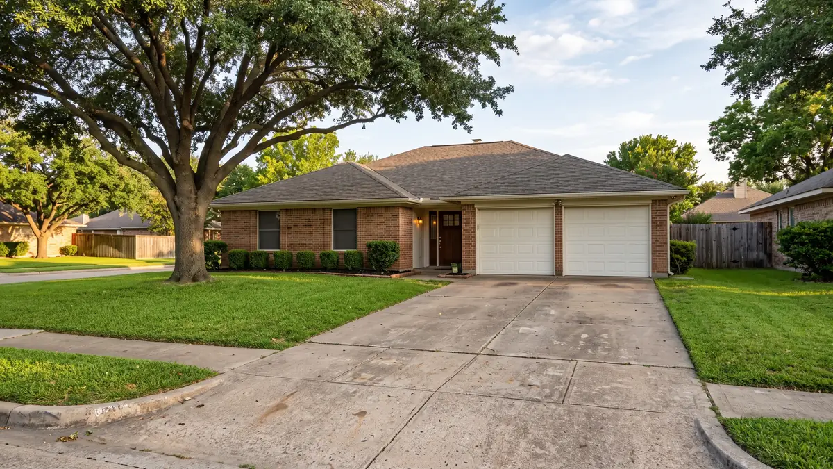 Driveway leading to a red-brown brick ranch under a huge live oak — slab leak detection in Corsicana, TX