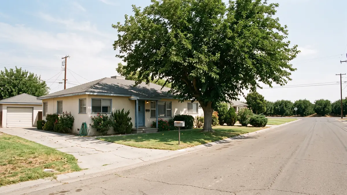Cream stucco ranch with a mulberry tree and orchard rows at the end of the street — slab leak detection in Merced, CA